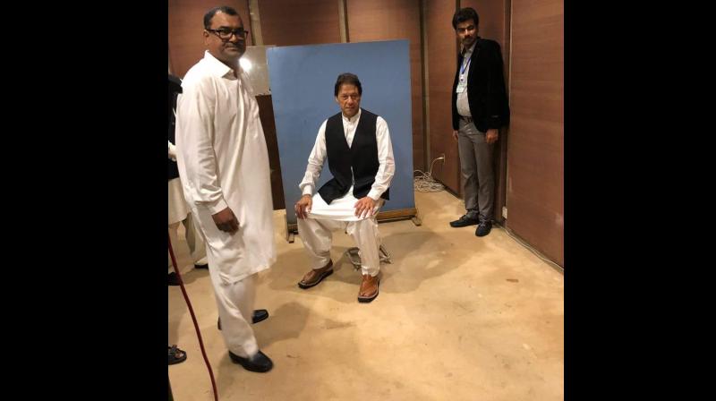 One of the National Assembly employees took off his black waistcoat and gave it to Imran Khan. The employee also helped him wear the waistcoat. (Photo: Twitter | @PTIofficial)
