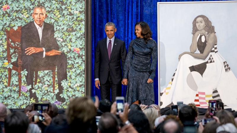 Former President Barack Obama and former first lady Michelle Obama stand on stage as their official portraits are unveiled at a ceremony at the Smithsonians National Portrait Gallery, Monday, Feb. 12, 2018, in Washington. (Photo: AP)