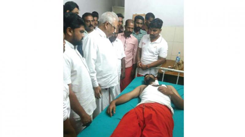 CPM Kannur district secretary P. Jayarajan visits Sarath Sasi who was injured in the bomb attack at Nangarath Peedika near Thalassery on Thursday. (Photo: DC)