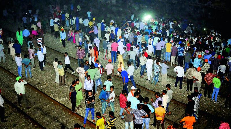 People gather near the site of a train accident at Joda Phatak in Amritsar on Friday.