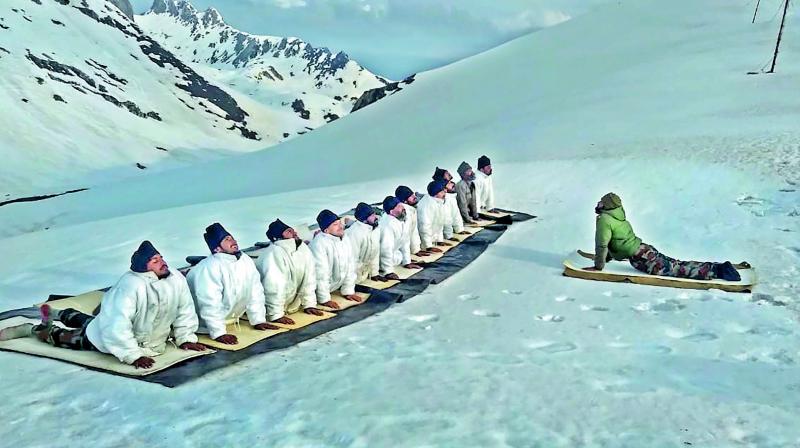 Indian Army personnel perform yoga to mark the 5th International Day of Yoga, in the icy ranges of the Himalayas on Friday.   (PTI)