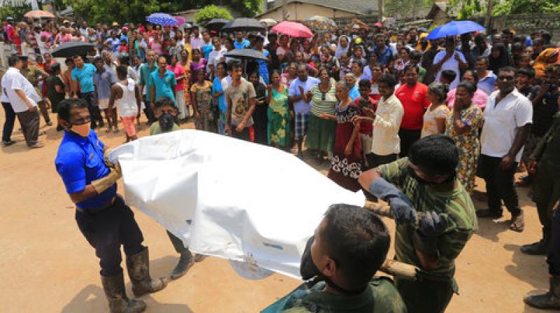 Sri Lankan government soldiers and rescue workers cary a body recovered from the site of a garbage dump collapse in Meetotamulla, on the outskirts of Colombo. (Photo:AP)