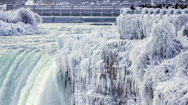 Visitors take photographs at the brink of the Horseshoe Falls in Niagara Falls, Ontario, as cold weather continues through much of the province on Friday, Dec. 29, 2017. (Photo: AP)