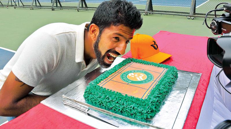 Rohan Bopanna strikes a pose with the cake at the KSLTA in Bengaluru on Saturday. (Photo: SATISH. B)
