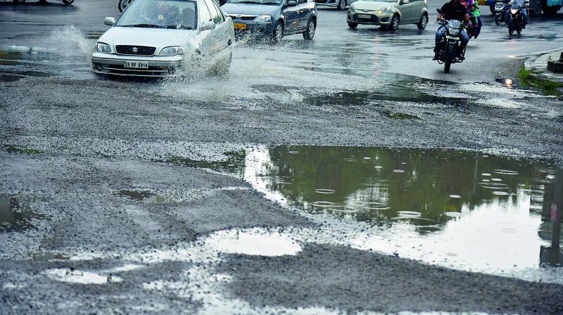 Motorists find it hard to negotiate on roads damaged by heavy rains, adding to the existing chaotic traffic in the city. (Photo: DC)
