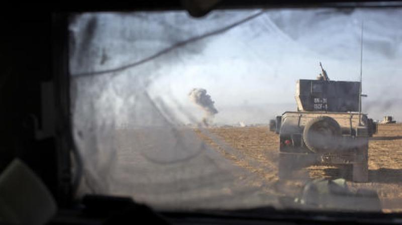 Iraqi special forces vehicles move as an airstrike hits an Islamic State militant position on the outskirts of Mosul, Iraq. (Photo: AP)