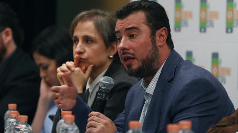 Mario Patron Sanchez, director of the Miguel AgustÃ­n Pro JuÃ¡rez Center for Human Rights, talks during a press conference, seated next to Mexican journalist Carmen Aristegui, in Mexico City. (Photo: AP)