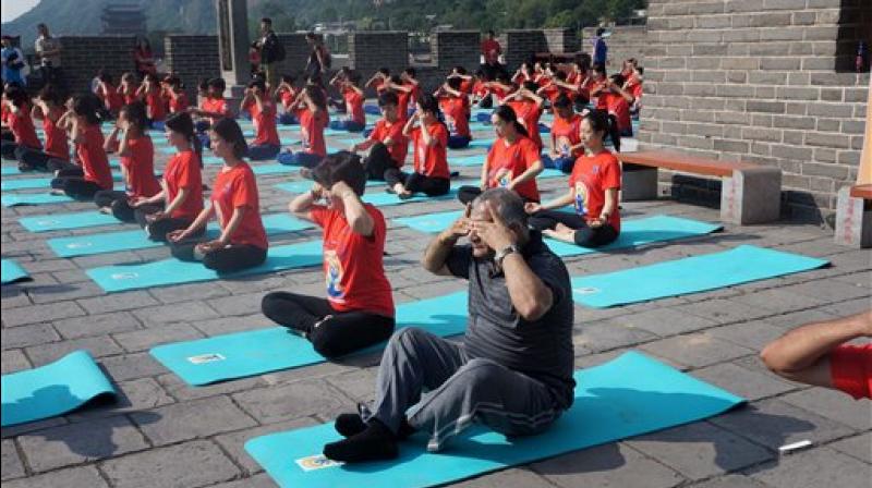 Minister of State for External Affairs VK Singh doing Bhramari Pranayam (a breathing technique) along with others at The Great Wall of China, a day ahead of International Yoga Day, in Beijing on Tuesday. (Photo: AP)