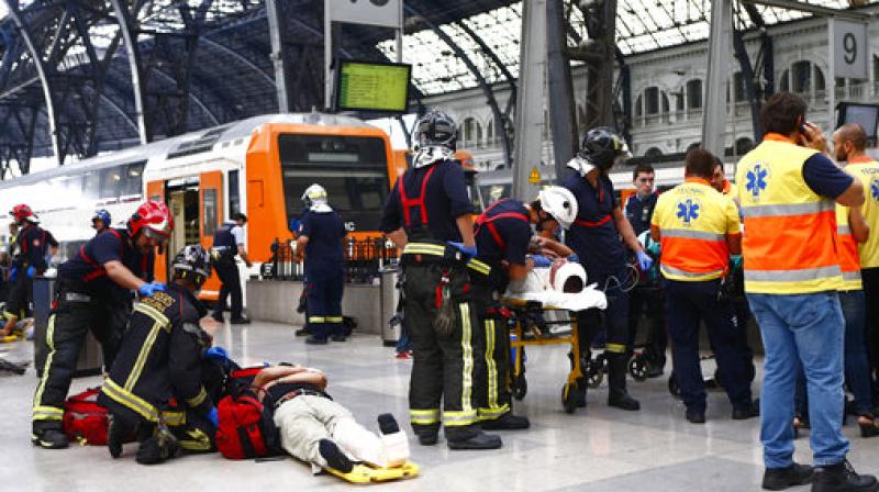 Injured passengers are attended to on the platform of a train station in Barcelona, Spain. Dozens of people were injured when a morning commuter train they were traveling on crashed into the buffers in a station in northeastern Barcelona early Friday. (Photo: AP)