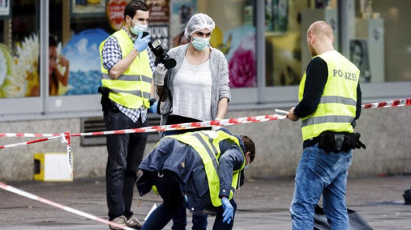 Police officers are securing evidence in front of the supermarket in Hamburg, Germany, where a man with a knife fatally stabbed one person and wounded four others as he fled, police said. He was then arrested. (Photo: AP)