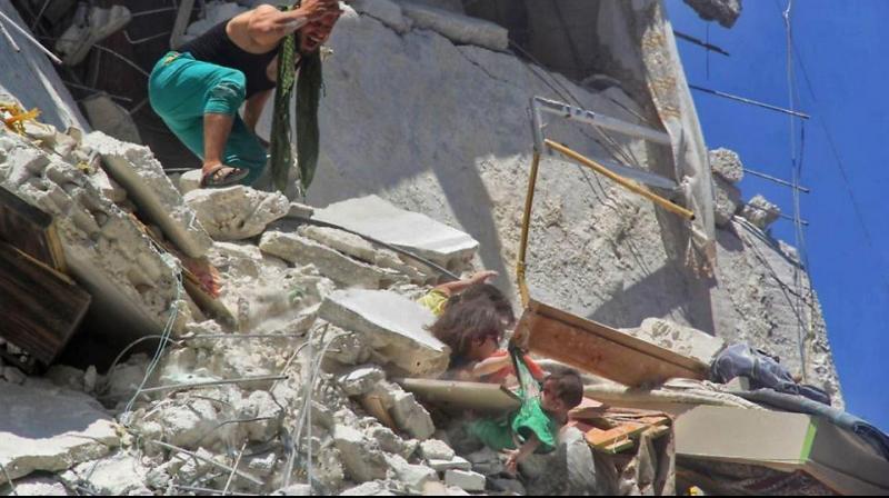 Photo: Syrian girl grabs baby sister from shirt in bombed buildingâ€™s rubble