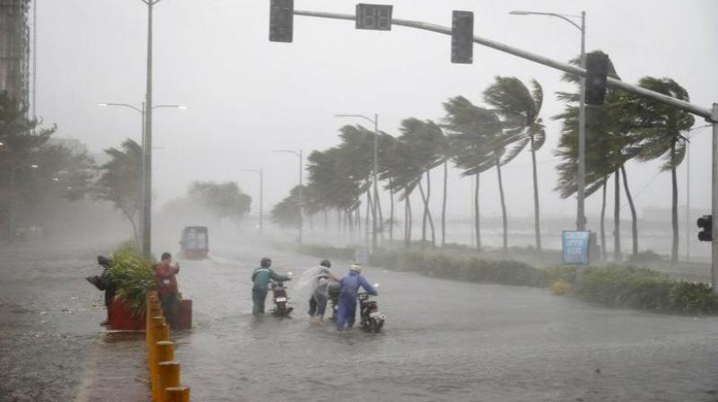 Motorists brave rain and strong winds brought about by Typhoon Mangkhut. (Photo: AP)