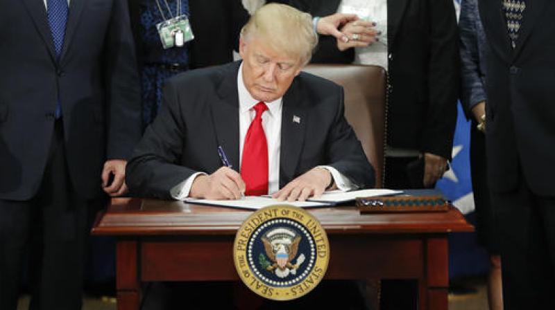President Donald Trump signs an executive order. (Photo: AP)