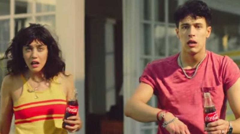 The Coca-Cola ad features a teenage girl ogling the pool boy from a downstairs window while her brother does the same from upstairs. (Credit: YouTube)