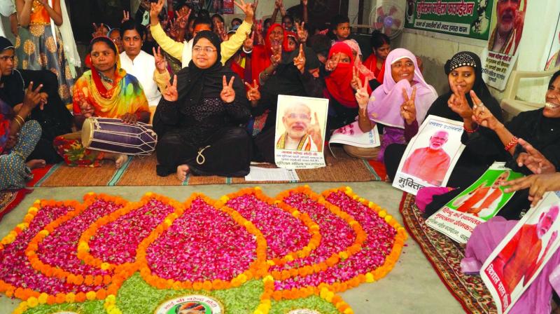 BJP supporters draw a lotus-shaped rangoli as they celebrate party victory in Varanasi on Thursday. (Photo: PTI)