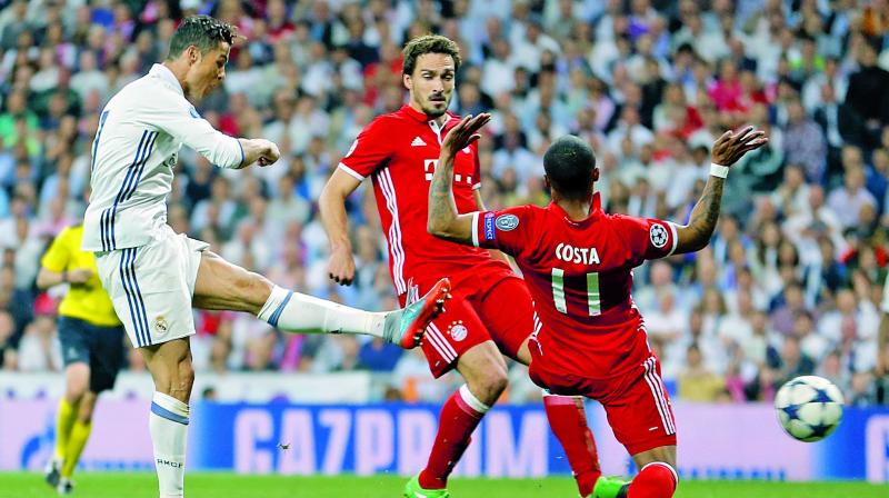 Real Madrids Cristiano Ronaldo (left) scores past Douglas Costa in their Champions League quarterfinal second leg match against Bayern Munich on Tuesday. Real Madrid won 6-3 on aggregate. (Photo: AP)