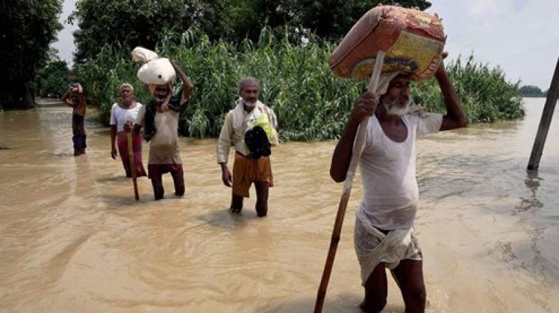 Flood-hit people shift with their belongings at Runni Saidpur in Sitamarhi district on Thursday. (Photo: PTI)