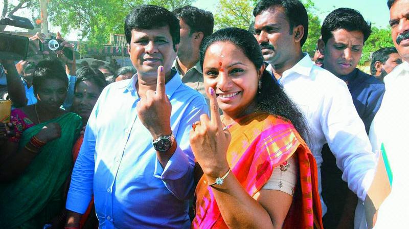 TRS candidate K. Kavitha shows her ink-marked finger after casting her vote along with her husband D. Anil Kumar, at a polling station, during the first phase of Lok Sabha polls, in Nizamabad on Thursday.