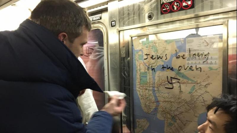 Commuter cleaning the hate message from the subway. (Photo: Facebook | Gregory Locke)