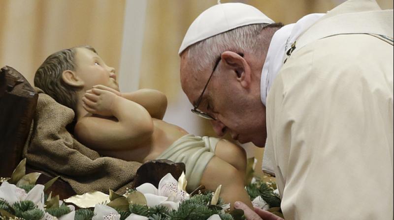 Pope Francis kisses during statue of baby Jesus a Mass in St. Peters Basilica, at the Vatican, to mark Epiphany. (Photo: AP)
