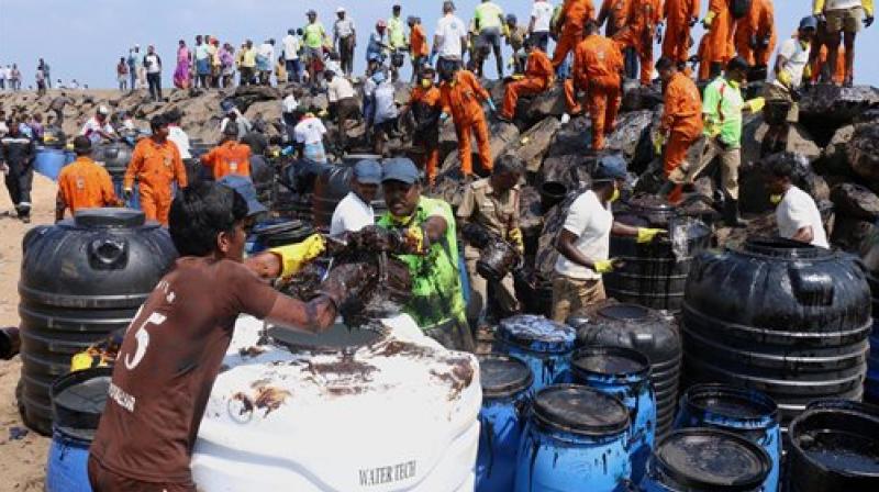 Coast Guard, State revenue personnel, local volunteers, and fishermen removing black oil washed ashore as a thick oily tide from the sea lapped at the coast. (Photo: PTI)