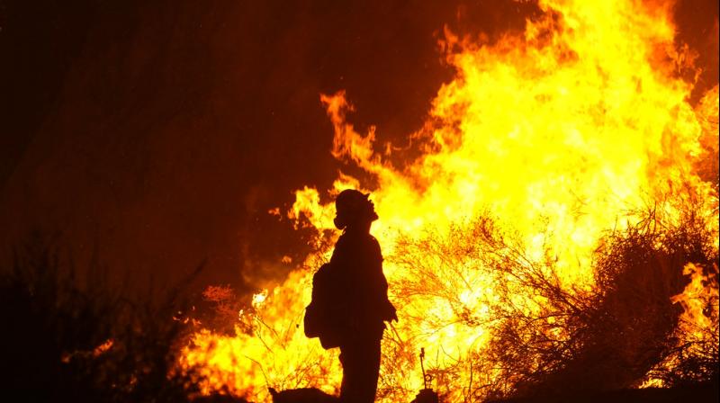A firefighter keeps watch as the Holy Fire burns in the Cleveland National Forest along a hillside at Temescal Valley in Corona, California. (Photo: AP)