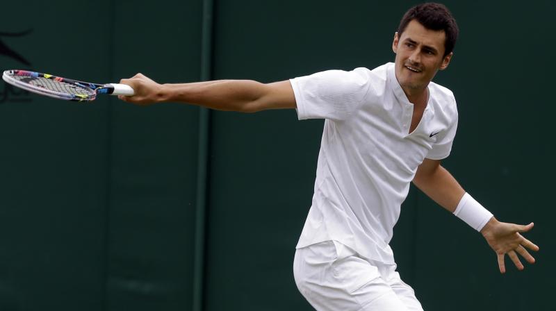 Australias Bernard Tomic returns to Germanys Mischa Zverev during their Mens Singles Match on day two at the Wimbledon Tennis Championships in London