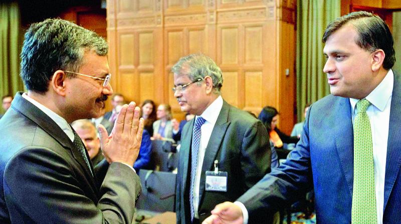 Dr Deepak Mittal, (left), joint secretary of Indias ministry of external affairs, greets Pakistans Syed Faraz Hussain Zaidi as they wait for judges to enter the World Court in The Hague, Netherlands, on Monday. (Photo: PTI)