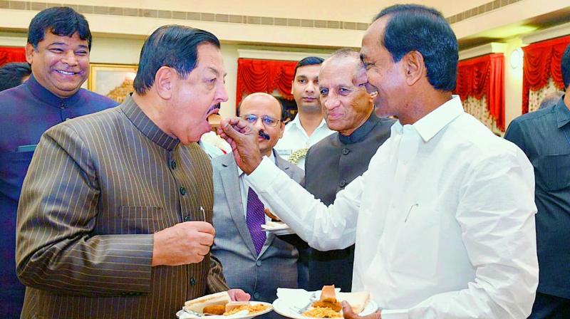 Telangana state Chief Minister K. Chandrasekhar Rao offers sweets to MIM senior legislator Mumtaz Ahmed Khan. Mr Kahn took oath as pro-tem Speaker of the Telangana State Legislative Assembly at Raj Bhavan on Wednesday.