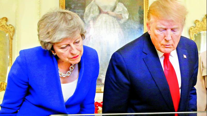 Britains Prime Minister Theresa May and US President Donald Trump are shown a copy of the American Declaration of Independence in 10 Downing Street in London on Tuesday. (Photo: AFP)