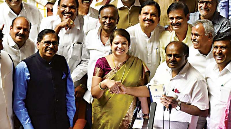 CM H.D. Kumaraswamy with his wife Anitha and Deputy CM  Dr G. Parameshwar after presenting the Budget.  (DC)
