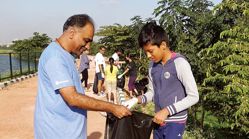 A schoolboy collects waste from Kalkare Lake in Bengaluru on Saturday. (Photo: DC)