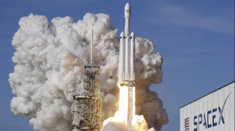 A Falcon 9 SpaceX heavy rocket lifts off from pad 39A at the Kennedy Space Center in Cape Canaveral. The Falcon Heavy, has three first-stage boosters, strapped together with 27 engines in all. (Photo: AP)