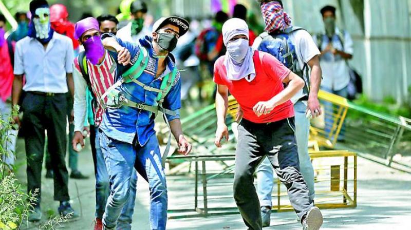 Kashmiri students throw stones on policemen as they clash in Srinagar in Kashmir. (Photo: AP)