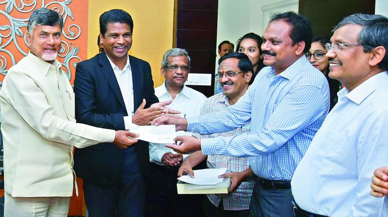 VIT vice-chancellor Sekhar Viswanathan presents Rs 50 crore cheque to CRDA commissioner Cherukuri Sredhar in the presence of Chief Minister Chandrababu Naidu at Camp Office in Vijayawada on Wednesday. (Photo: DC)