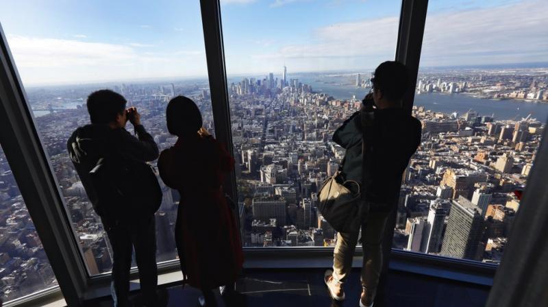 Workers mounted metal baskets suspended outside the 103rd floor, wearing harnesses attached to the building. (Photo: AP)
