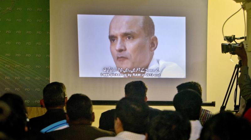 In this March 29, 2016 photo, journalists look a image of Indian naval officer Kulbhushan Jadhav. (Photo: AP)