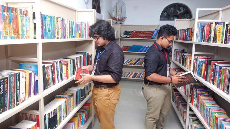 Anirudh Mahesh and Amir Fadil sorting books at the library. (Photo: DC)