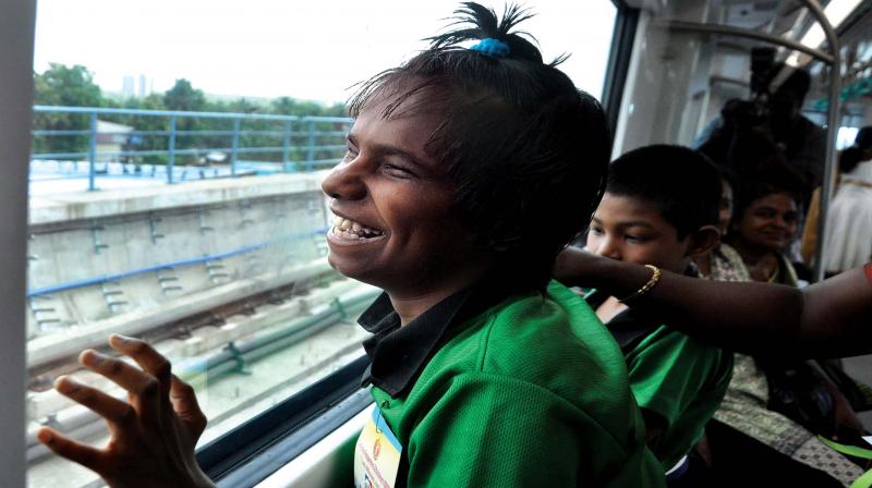 Mary Helen of Keezhmadu Blind School, Aluva, feels the glass window of Kochi Metro as she follows the narration of her teacher about the features of the train and the view outside during her ride from Kalamassery to Aluva on Sunday. (Photo: SUNOJ NINAN MATHEW)