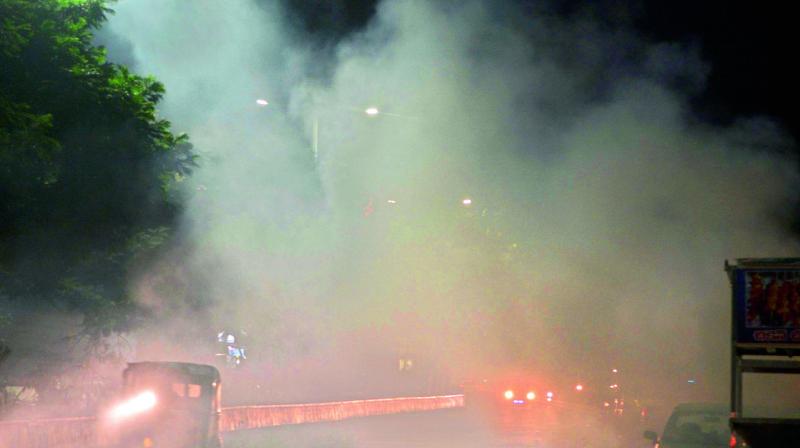 A file photo of burning garbage on the road blocking visibility in Vijayawada.
