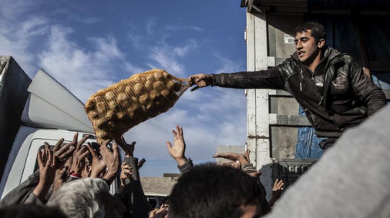 An Iraqi man distributes potatoes to civilians in the Samah district of Mosul, Iraq. (Photo: AP)