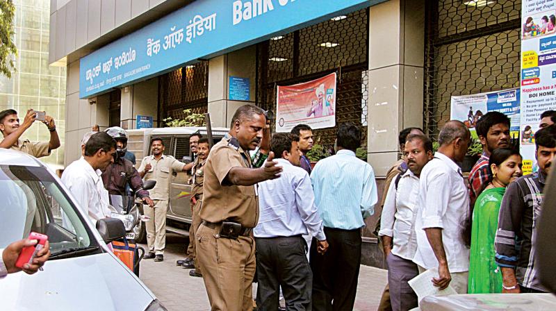Police outside the Bank of India branch on K.G. Road after the heist, in Bengaluru on Wednesday.
