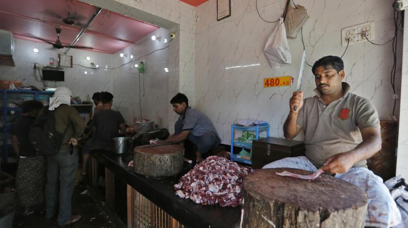 A man chops meat at a meat shop. (Photo: AP)