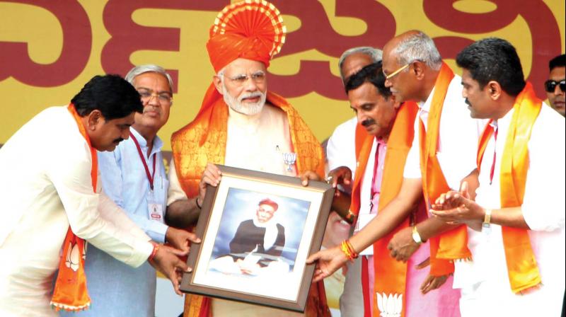 Prime Minister Narendra Modi at an election rally at Jamkhandi in Bagalkote district on Sunday. (Right) BJP supporters at Modis rally in Raichur. 	 (Photo:KPN)