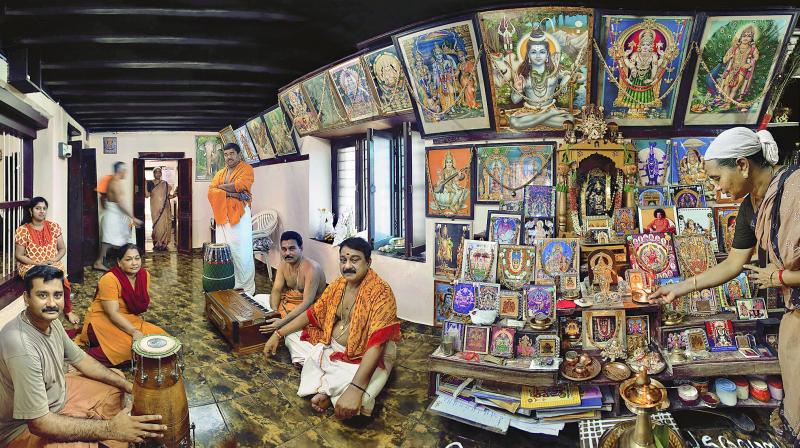 Mohan Manjapra, 61, seated on the floor wearing a yellow shawl, is a popular singer of Namasankirthanam  devotional singing in the Carnatic musical tradition of southern India. He is photographed here in the puja room of his family home.