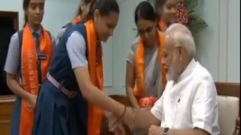 Women, school students tie rakhi on PM Modi\s wrist