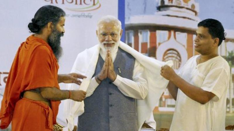 Prime Minister Narendra Modi being welcomed by Swami Ramdev and Balkrishan at the inauguration of the Patanjali Research Institute in Haridwar, Uttarakhand on Wednesday. (Photo: PTI)