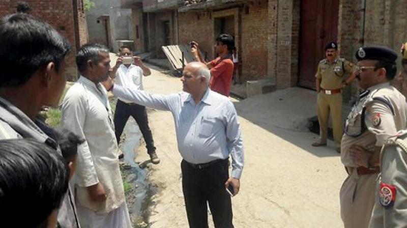 UP Home Secretary Mani Prasad Mishra talks to the persons affected by the violence in Saharanpur, in Shabbirpur on Wednesday. (Photo: PTI)