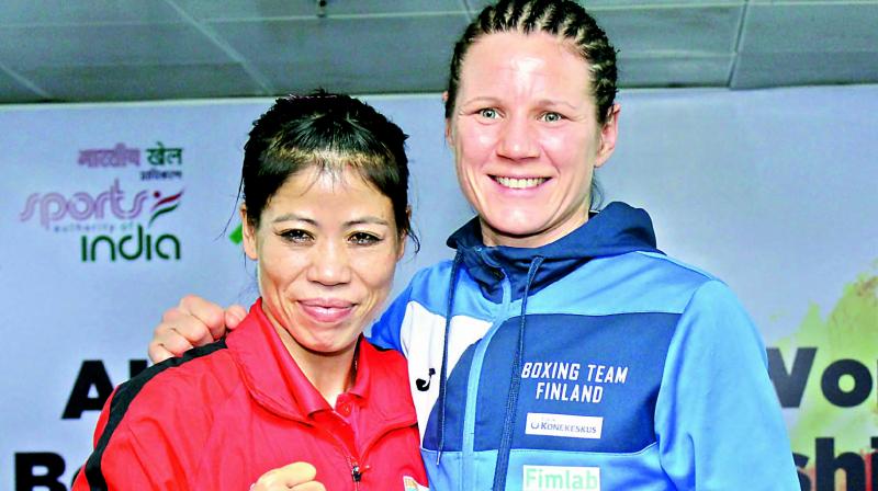 Five times gold medalist M. C. Mary Kom (left) and 2016 Rio Olympics bronze medalist Mera Potkonen pose at a press conference in New Delhi.