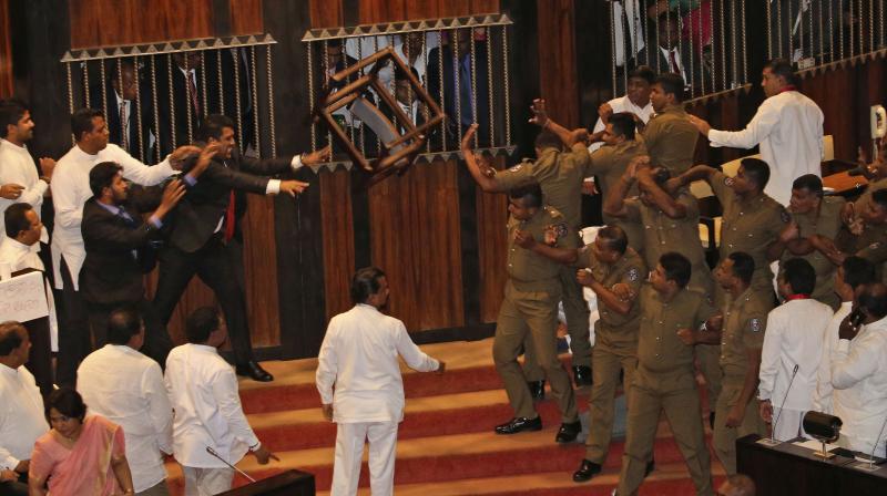 Lawmakers supporting disputed Prime Minister Rajapksa throw a chair towards police officers escorting the speaker inside parliament in Colombo, Sri Lanka, Friday, November 16, 2018. (Photo: AP)